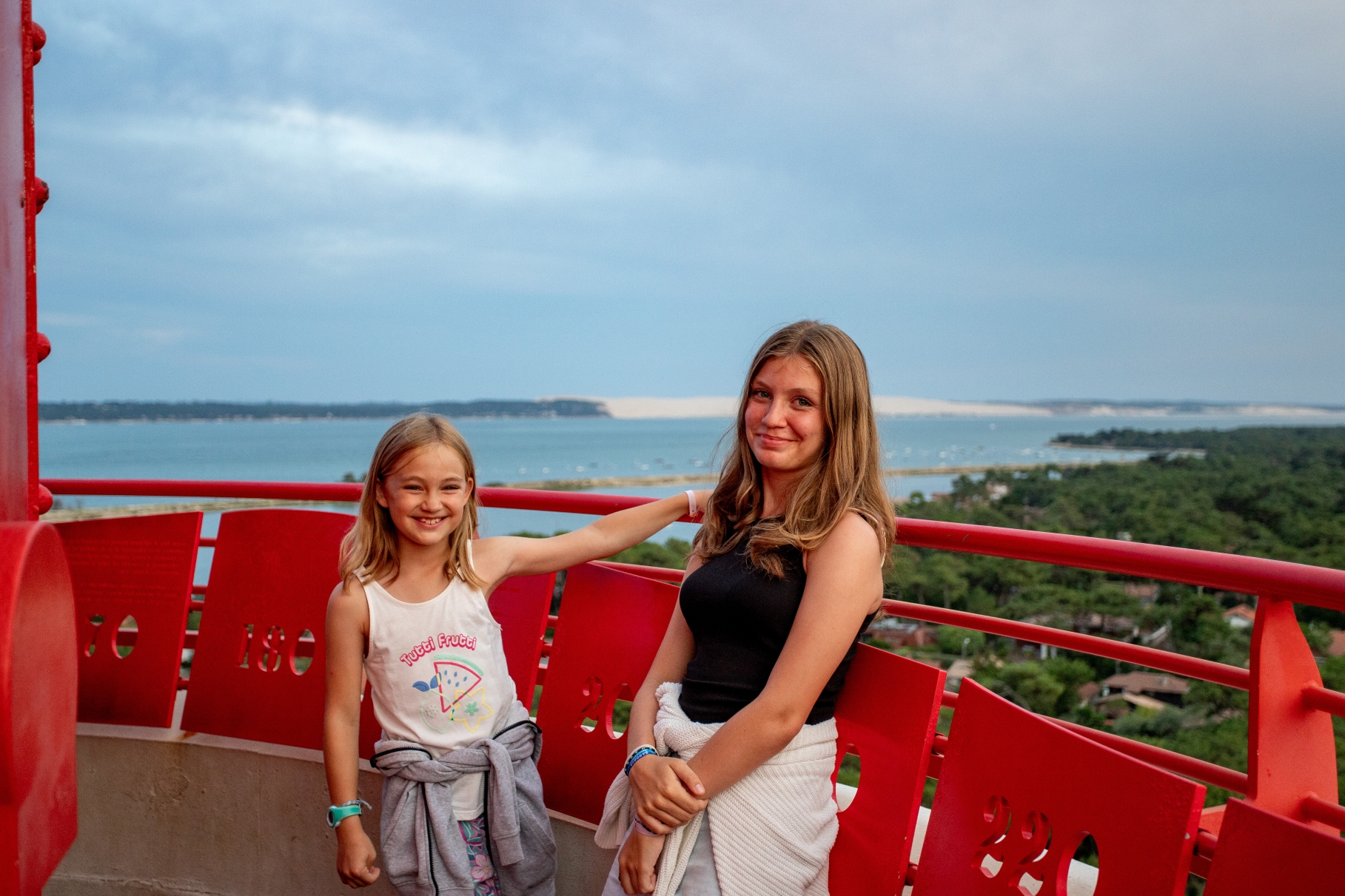 Elles prennent la pose pour une photo au sommet du phare, immortalisant leur ascension et la vue panoramique.