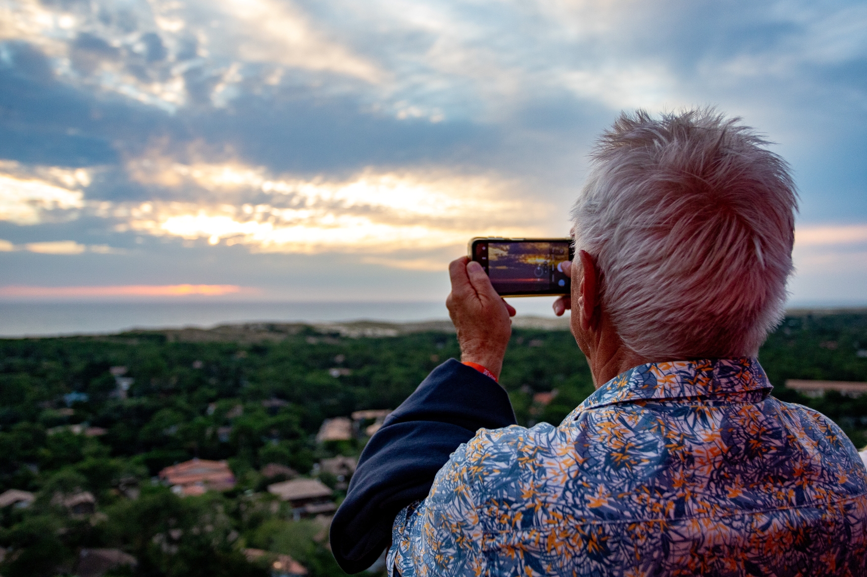 Lors des nocturnes, un visiteur capture la beauté du paysage depuis le sommet du phare, pour garder ce moment en mémoire.