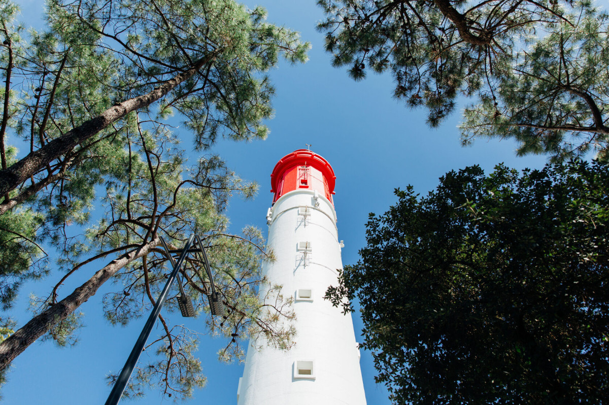 Vue aérienne du Phare du Cap Ferret entouré de pins.