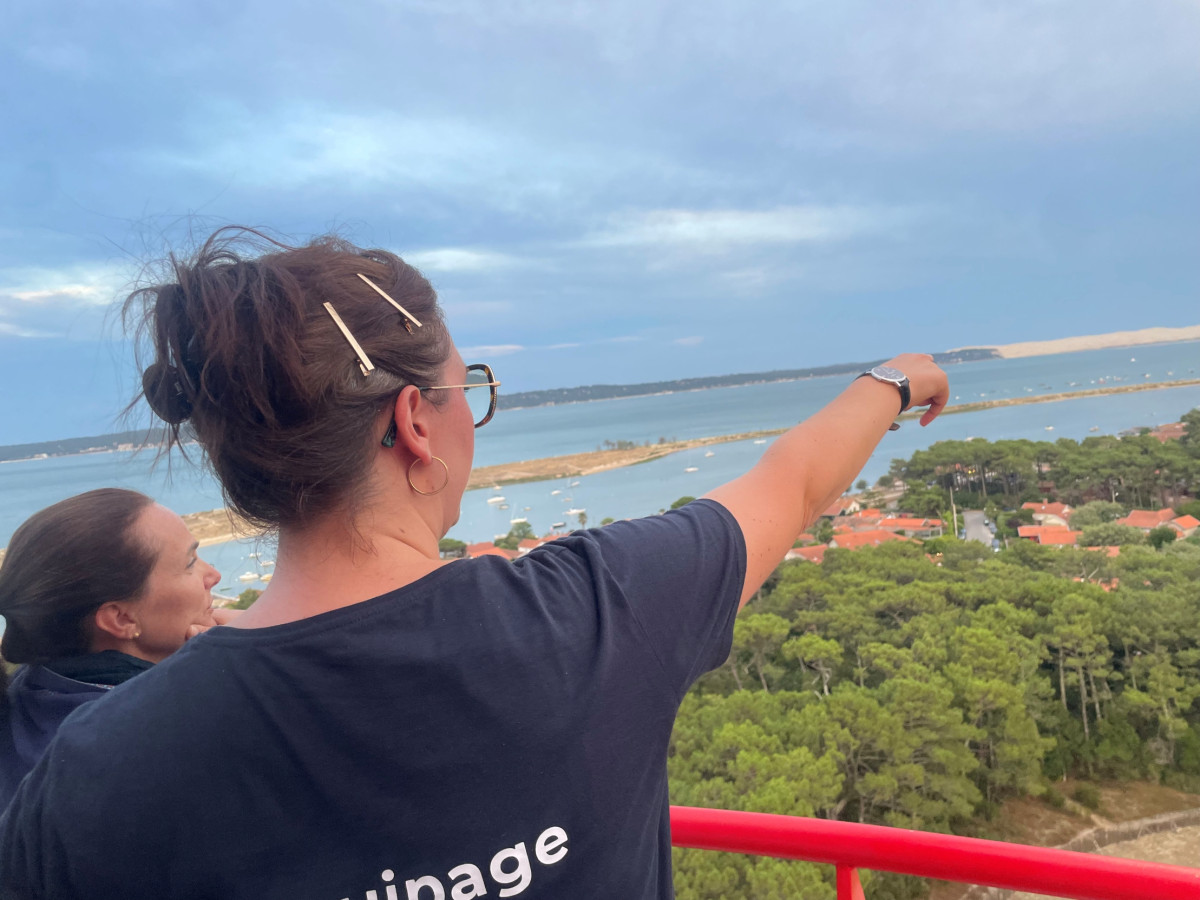Un membre de l’équipage explique l’histoire et le fonctionnement du phare à un visiteur, depuis le sommet.