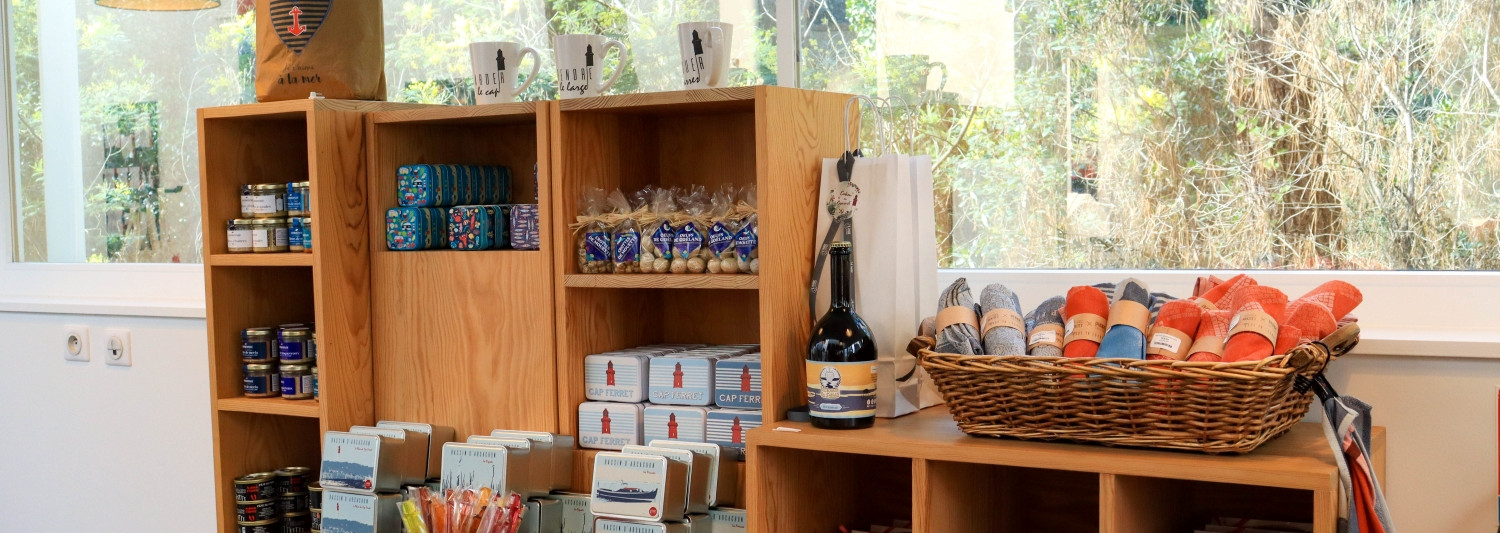 Aperçu de la boutique du Phare du Cap Ferret présentant la sélection d’art de la table, de produits locaux et de gourmandises disponibles pour les visiteurs.