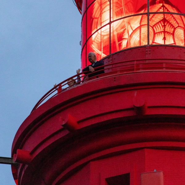 Depuis le sommet du phare, les visiteurs observent attentivement le paysage qui se déploie sous leurs yeux.
